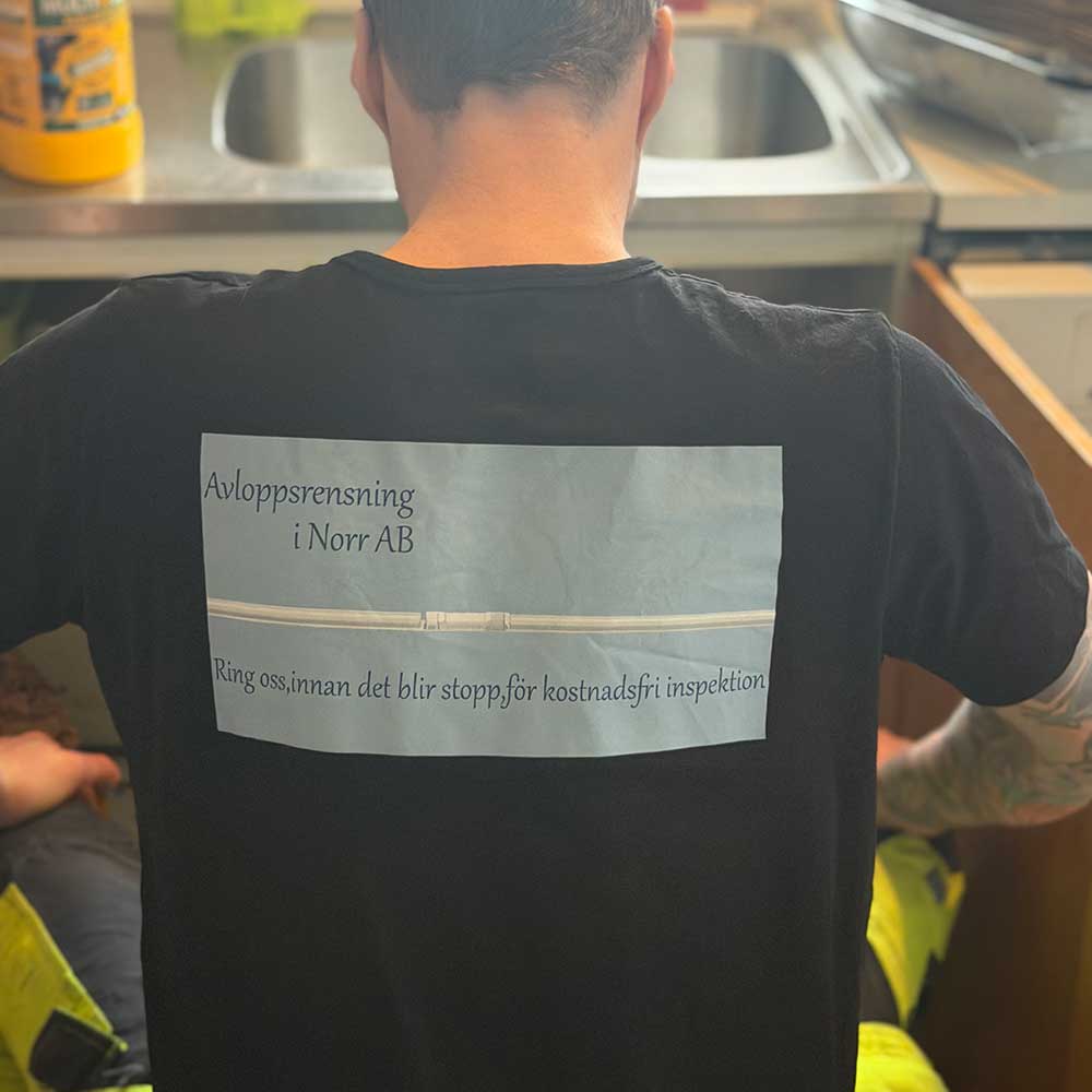 Man som kontrollerar ett avlopp i köket